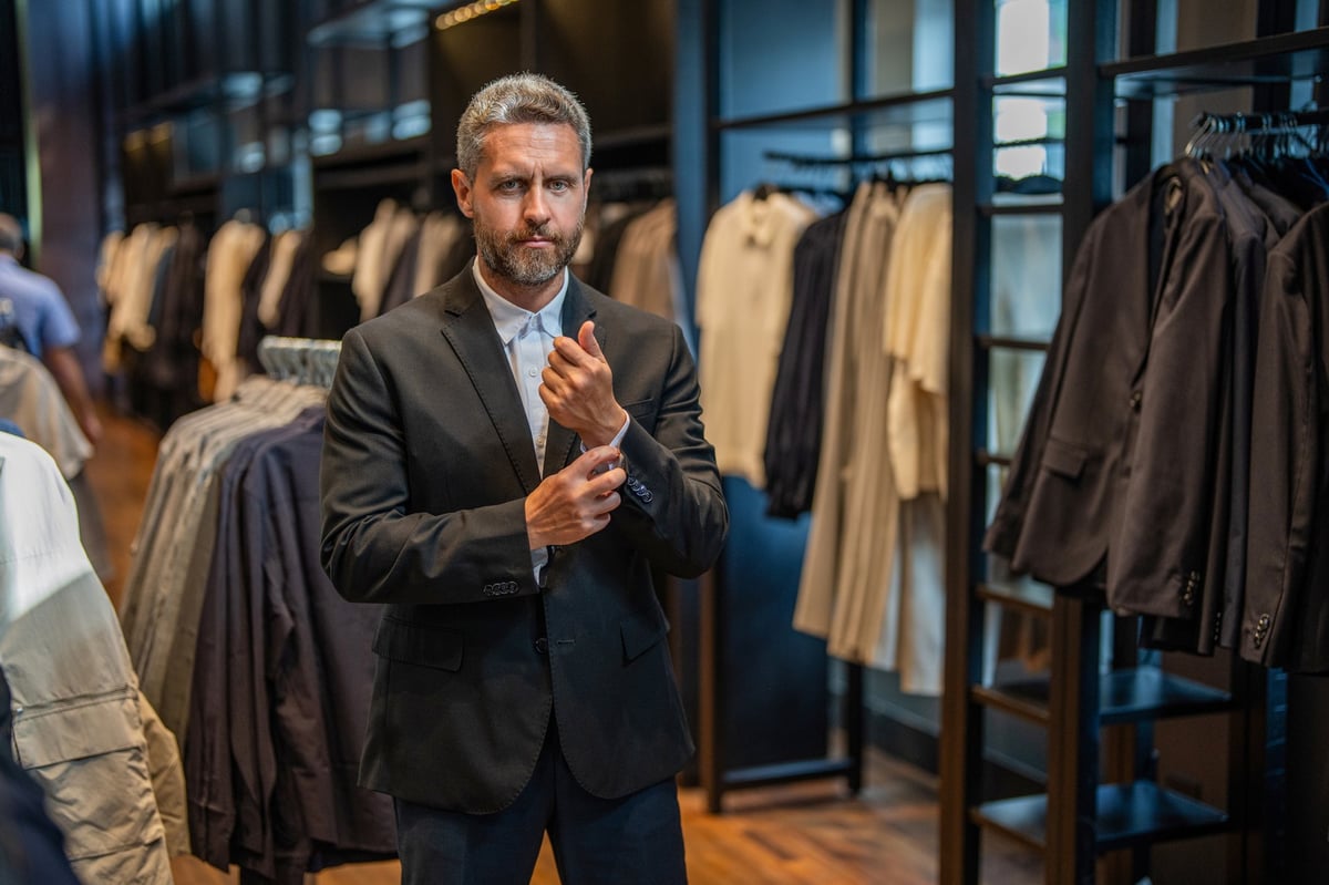 Stylish man being helped in suit store